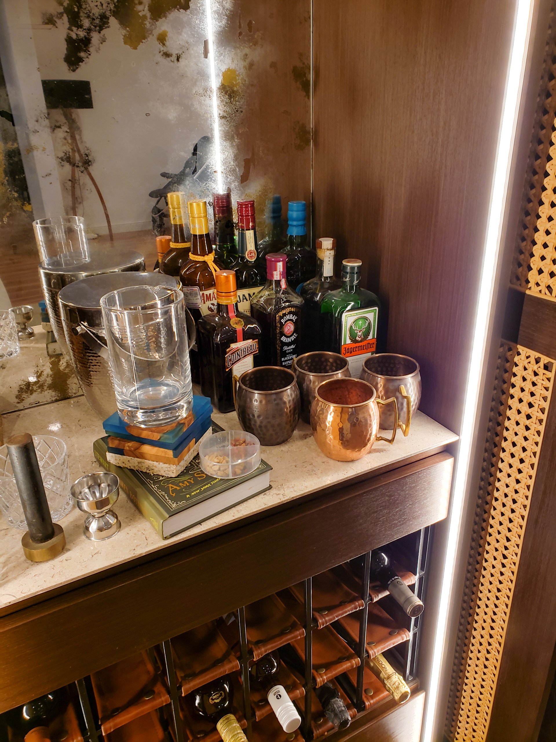 Un bar lleno de botellas, tazas, libros y vasos.