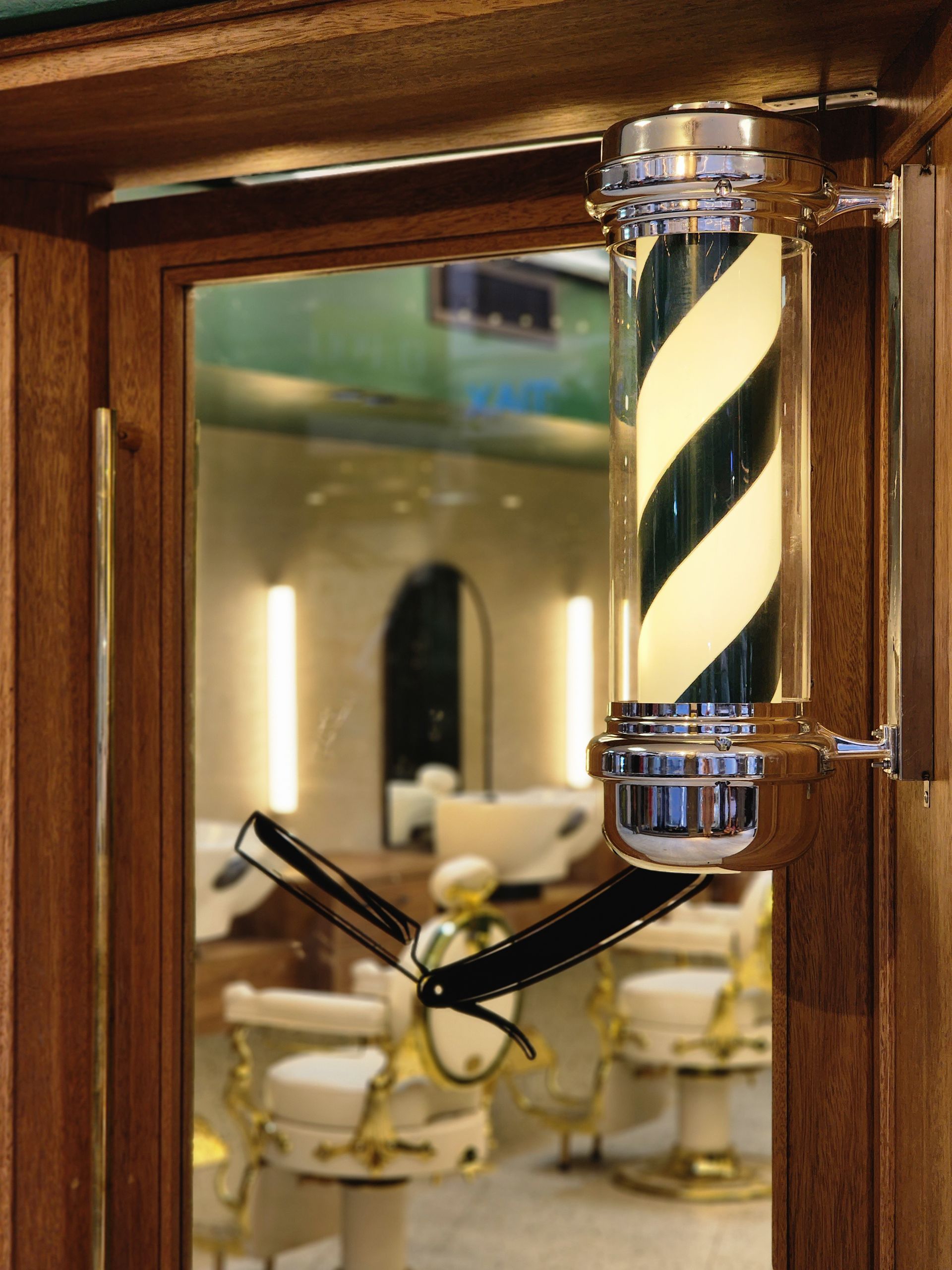 Una barbería con un espejo y un poste de barbero.