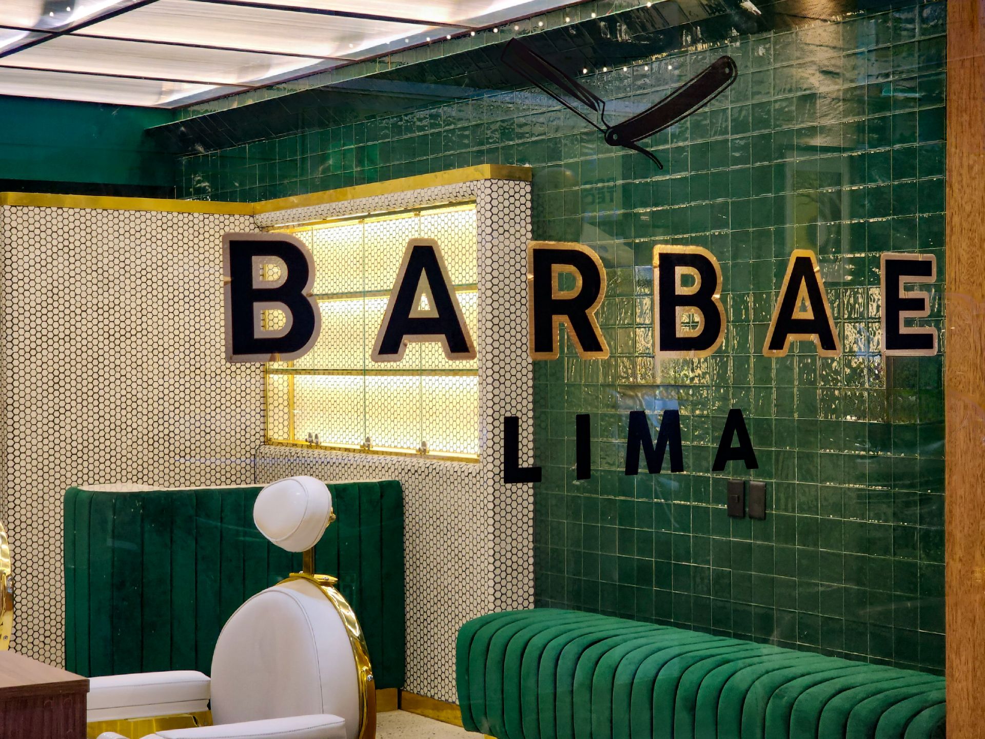 Una barbería con una pared verde y una silla de barbero.