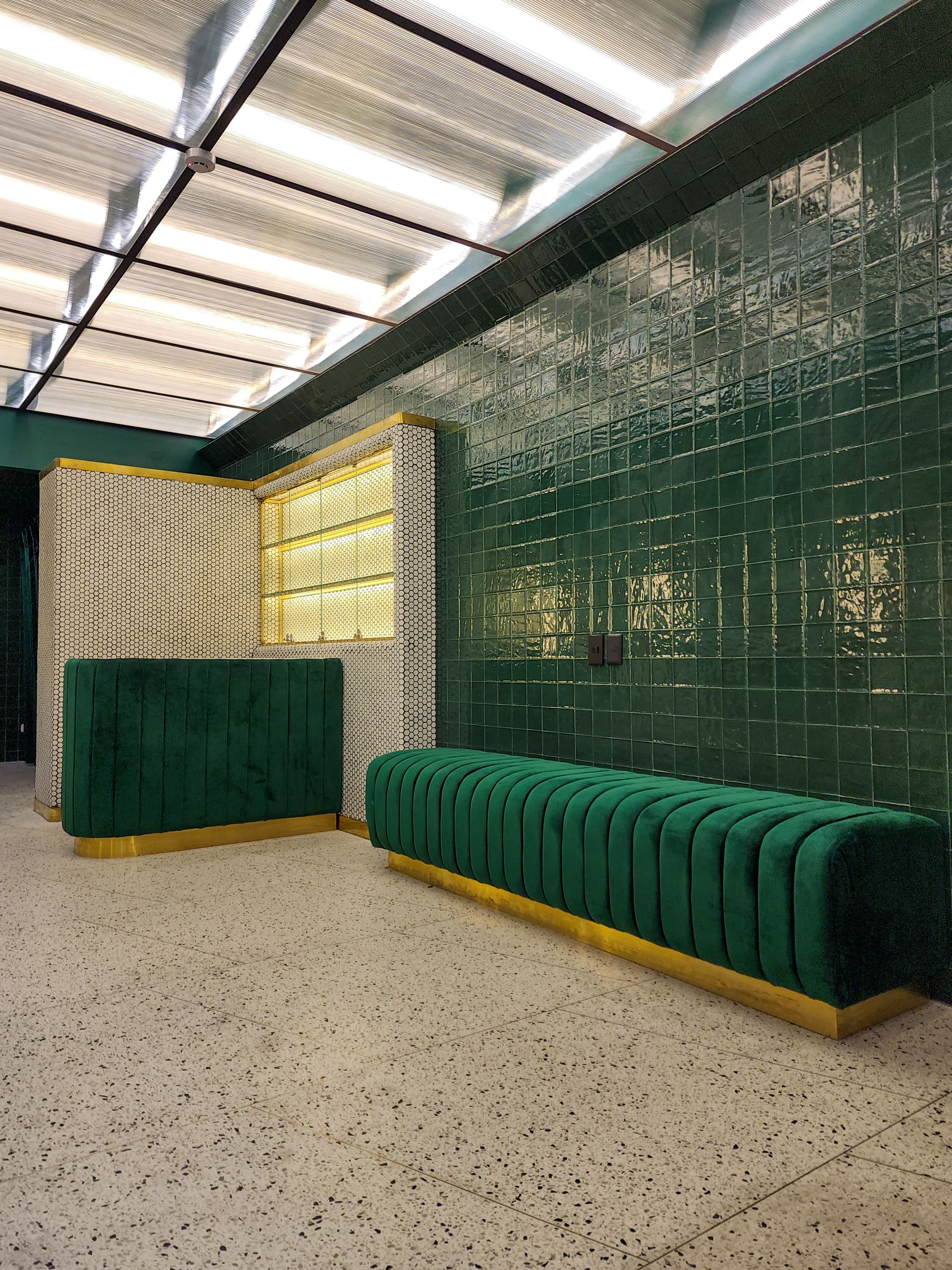 Hay un banco verde en el medio de la habitación.