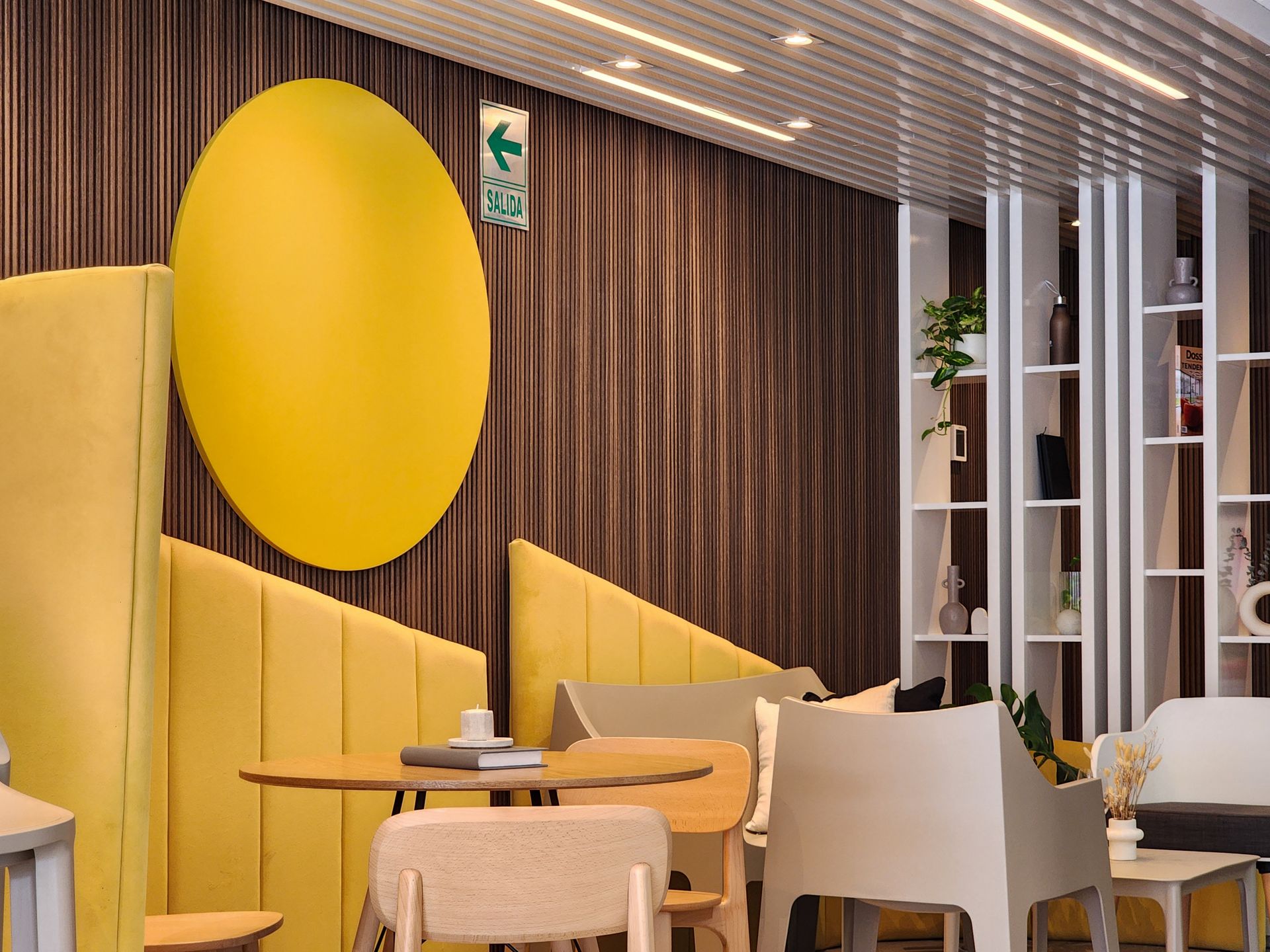 Una habitación con mesas y sillas y un círculo amarillo en la pared.