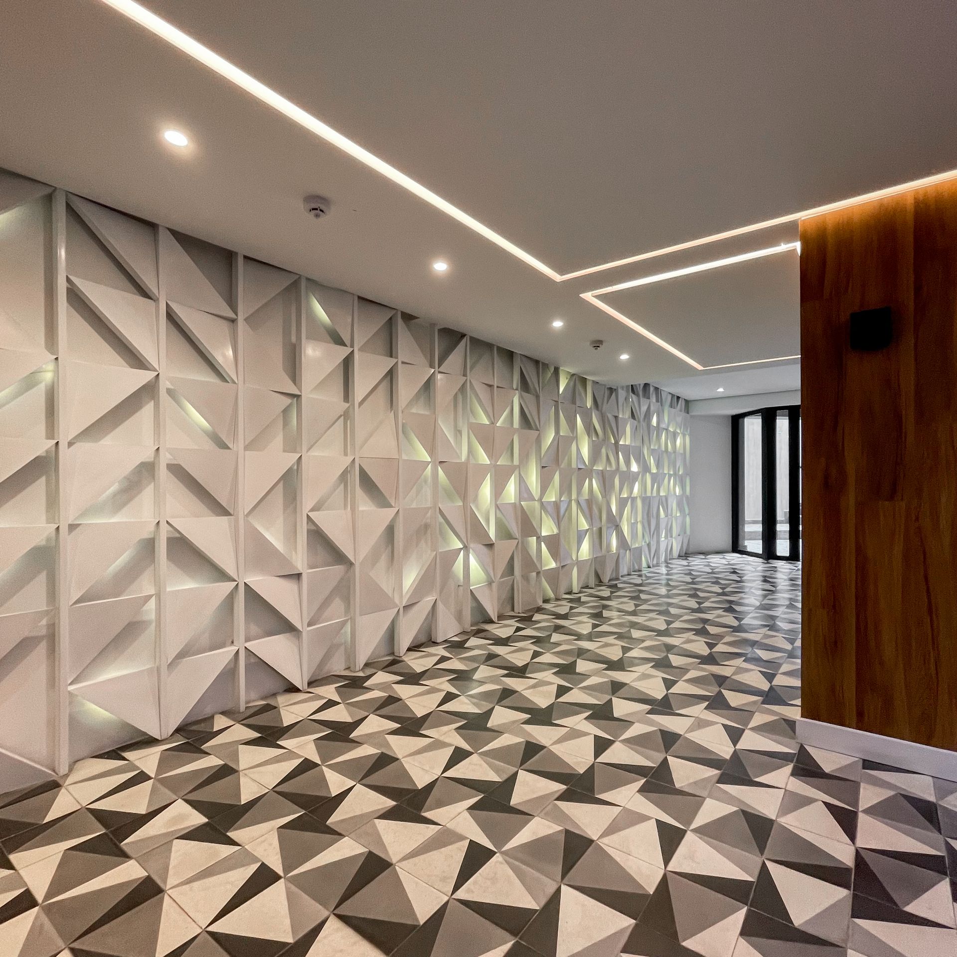 Un pasillo con un patrón geométrico en el suelo y las paredes.