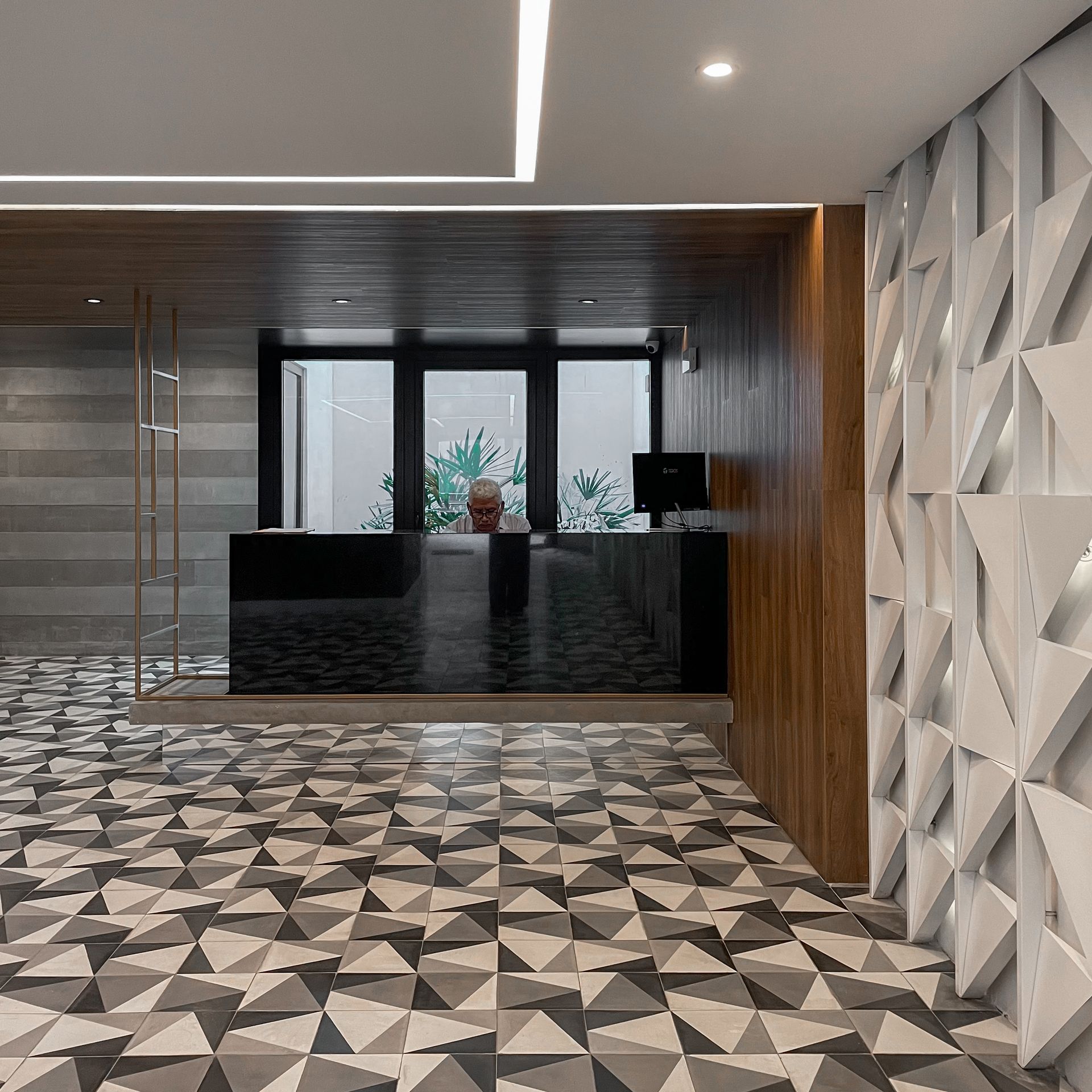 Una habitación con un suelo con motivos geométricos y un mostrador de recepción.