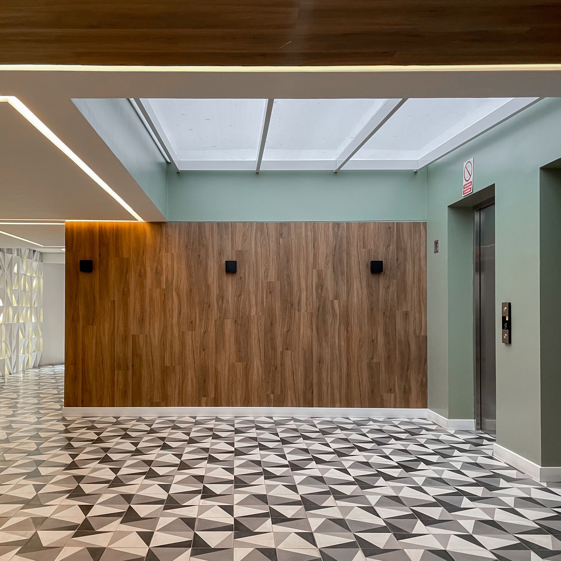 Un pasillo con una pared de madera y un suelo con motivos geométricos.