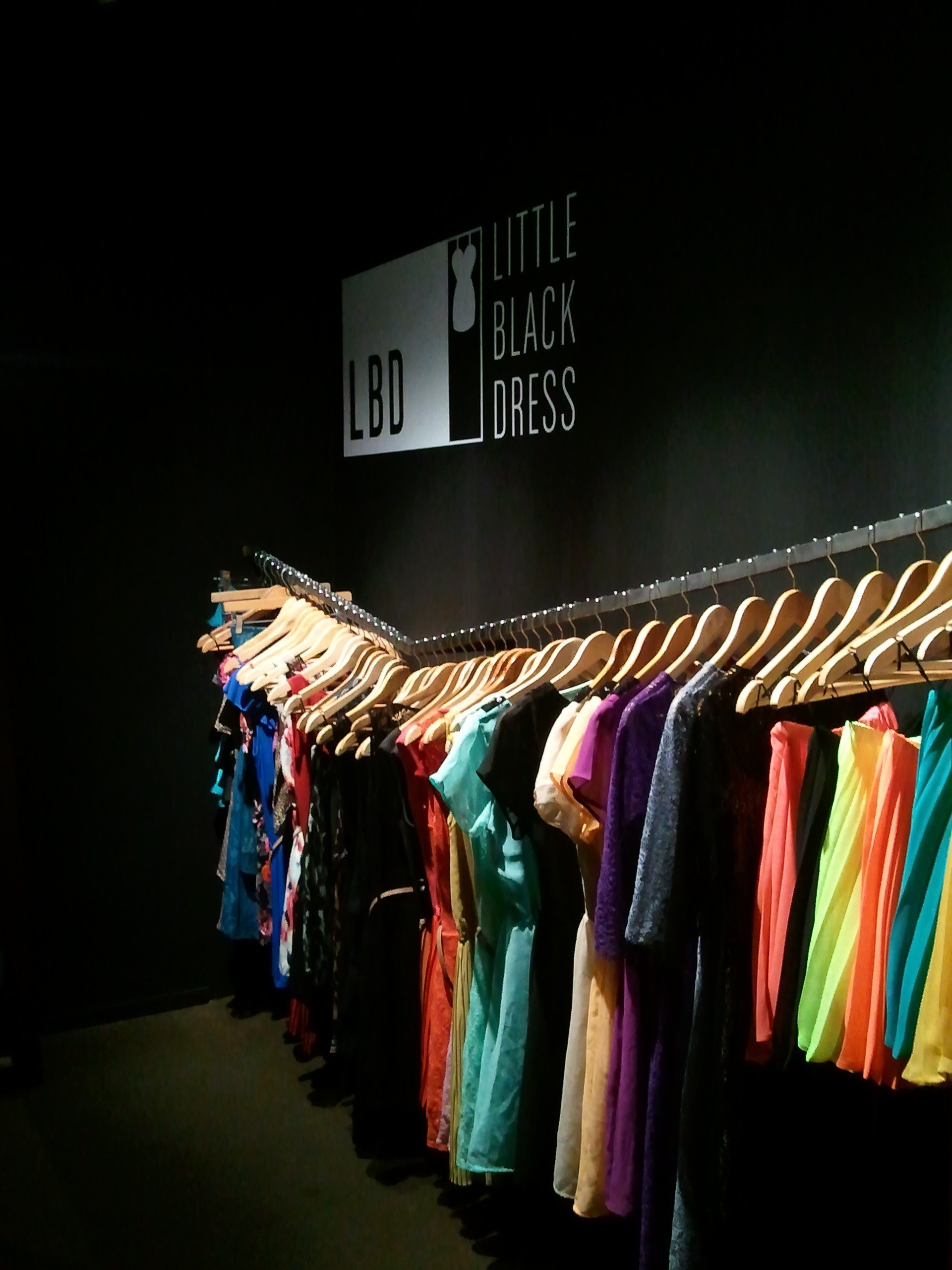 Una fila de ropa cuelga delante de un cartel que dice 