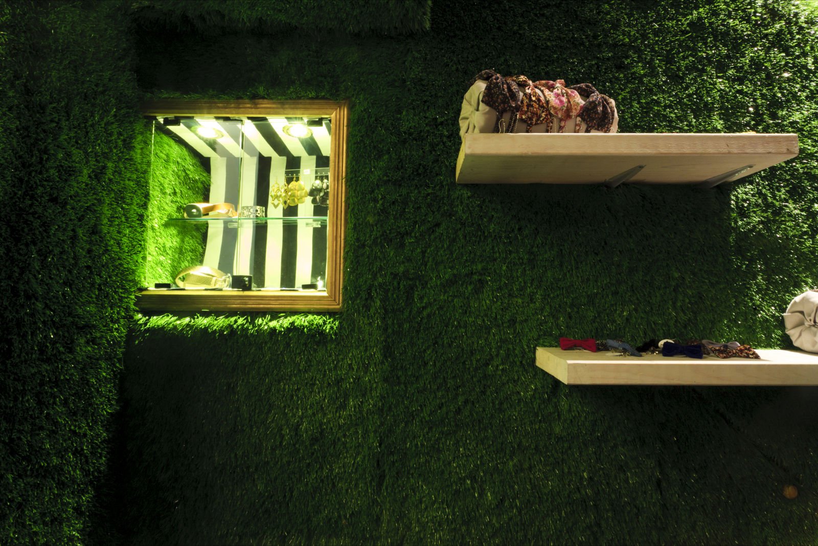 Una pared verde con dos estantes y una ventana.