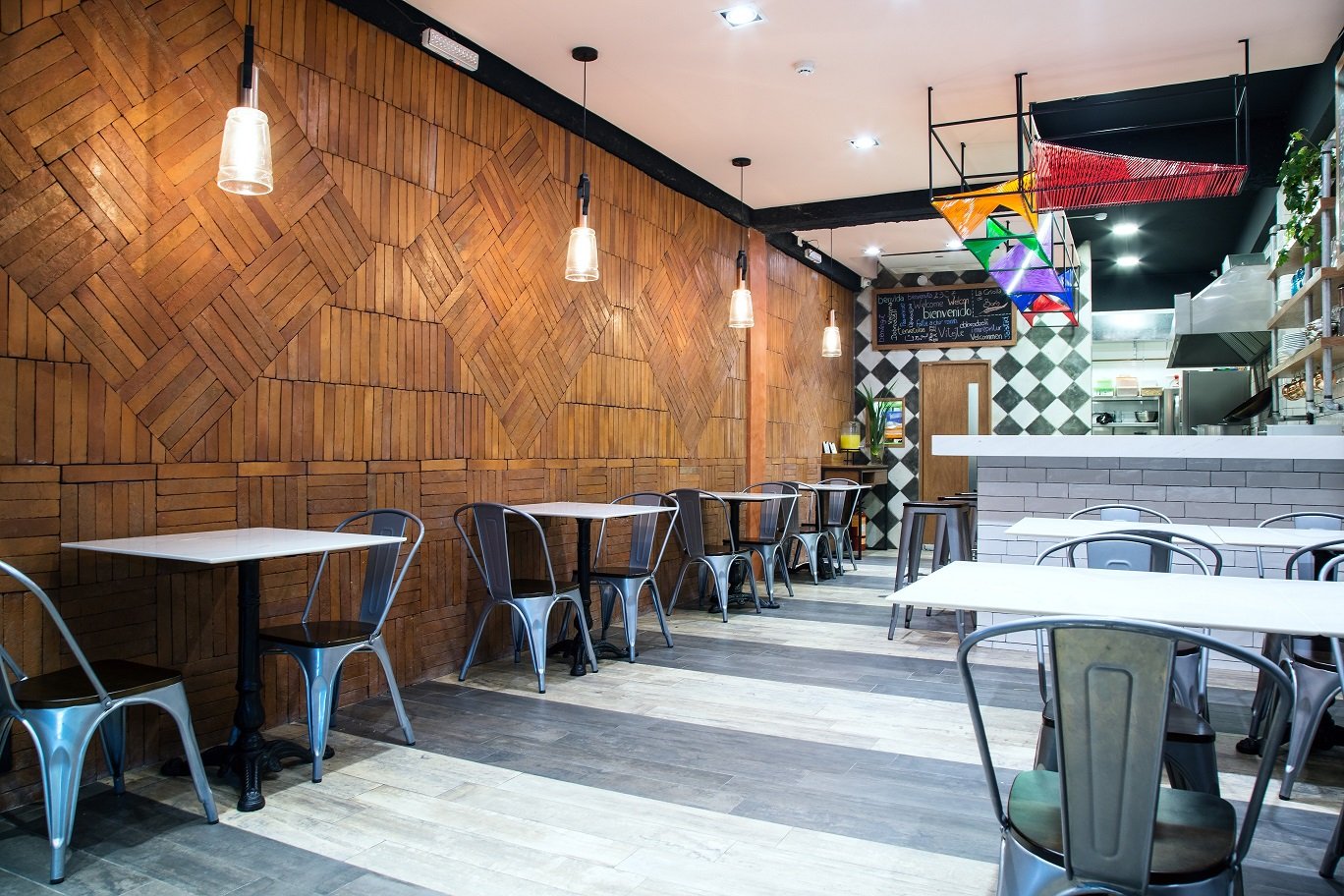 Un restaurante con mesas y sillas y una pared de madera.