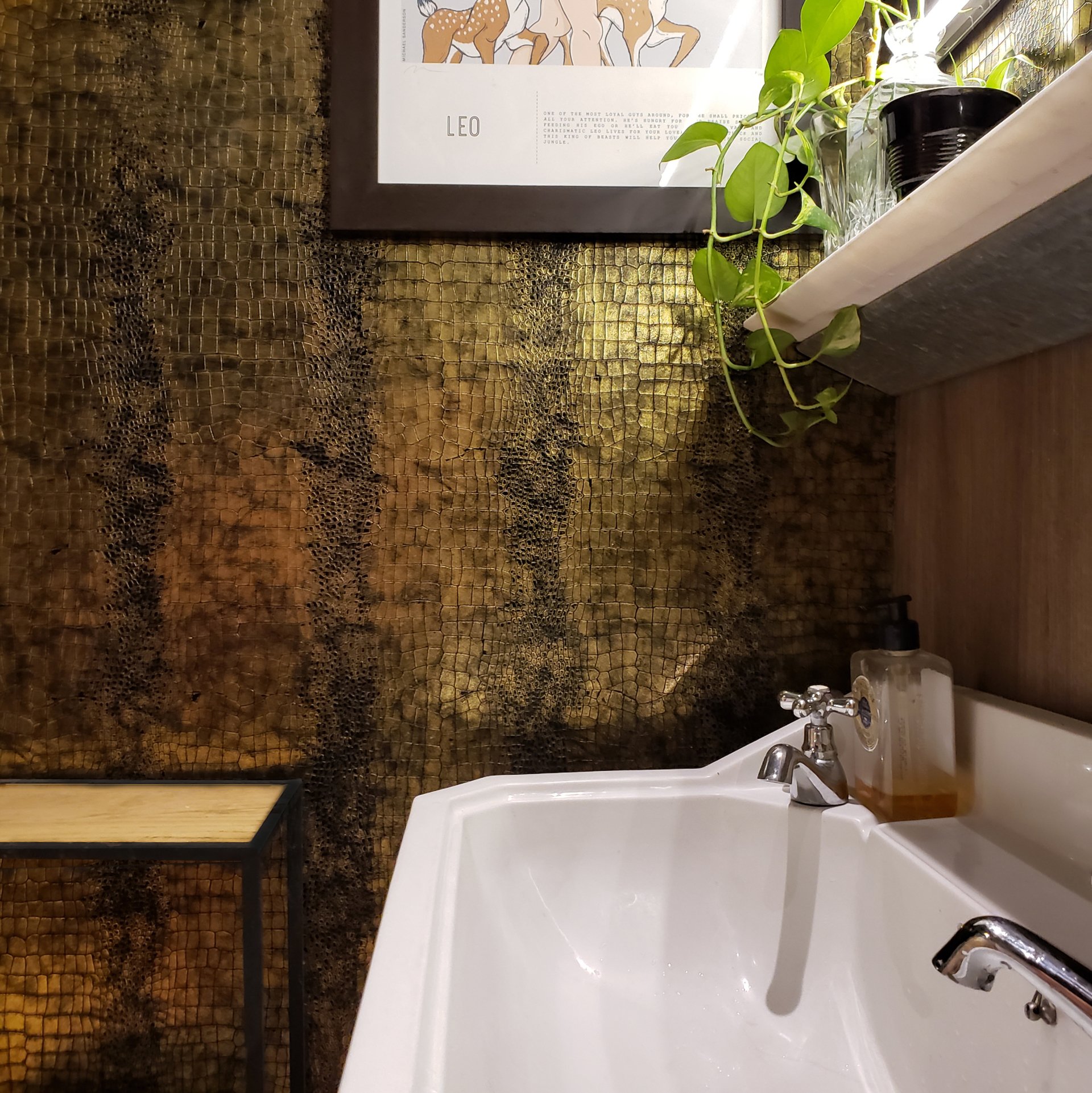 Un baño con un cuadro en la pared encima del lavabo.