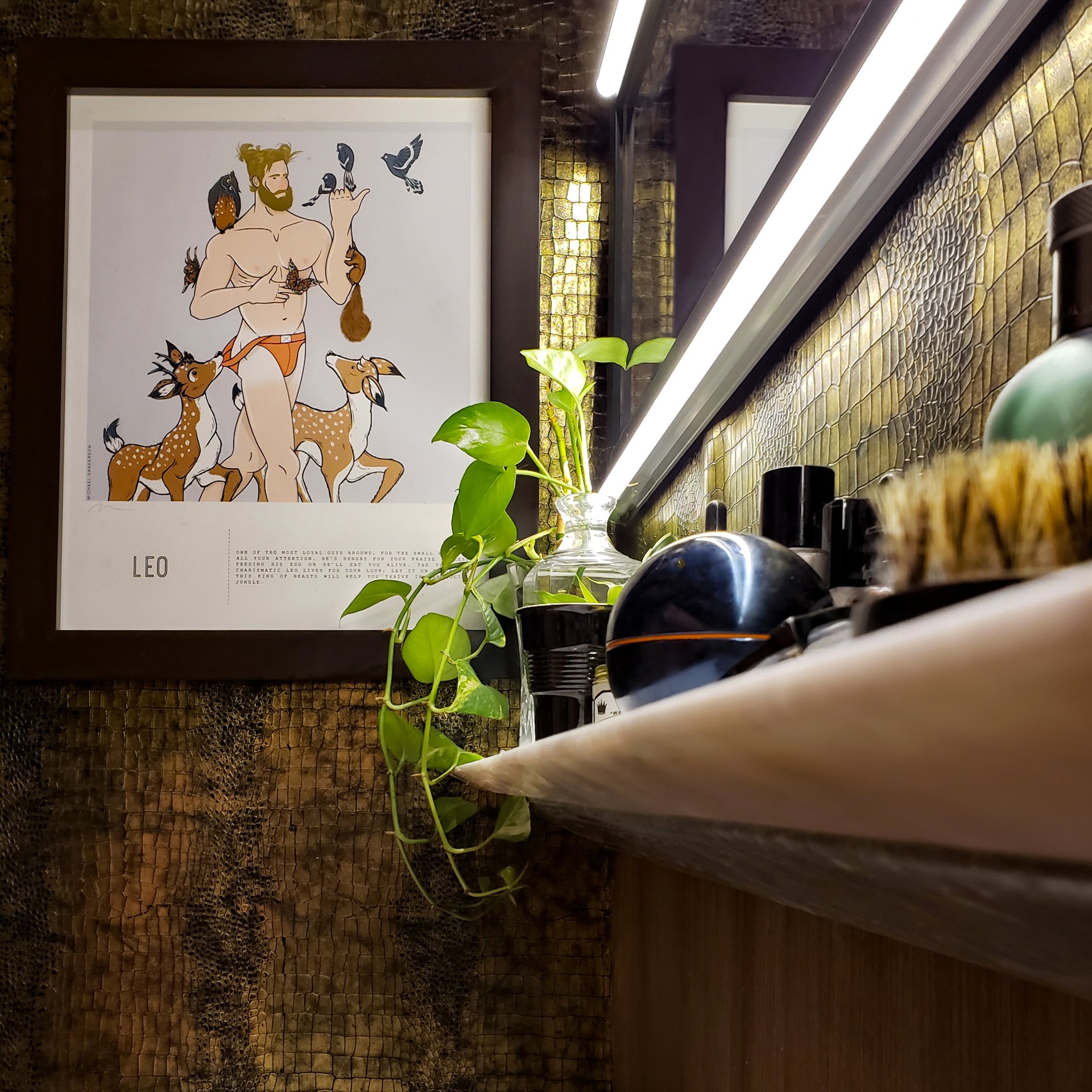 Una fotografía enmarcada de un hombre con animales está en una pared encima de un estante.