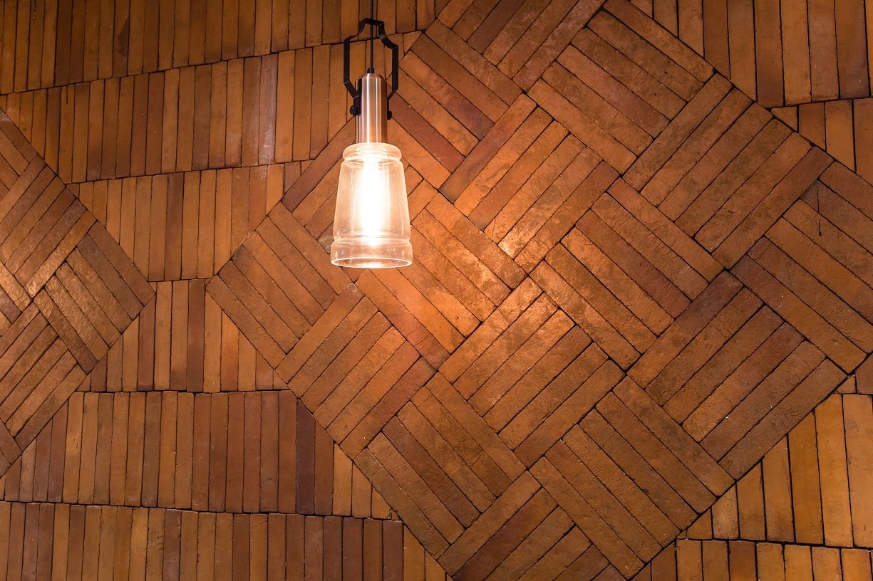 Una pared de madera con una luz colgando de ella.