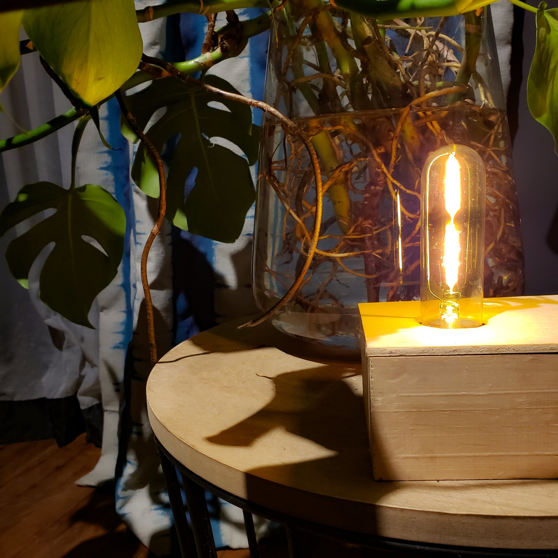 Una bombilla está sobre una caja de madera sobre una mesa.