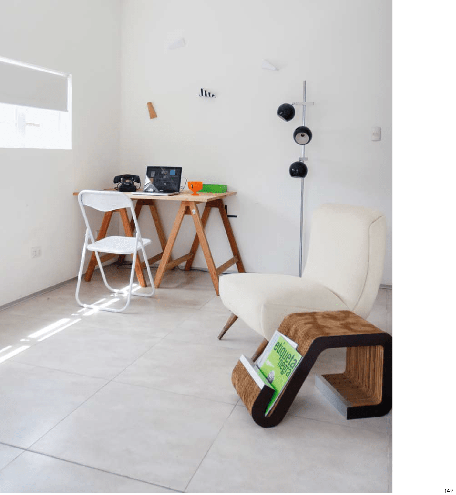 Una habitación con una silla y un escritorio con una computadora portátil encima.