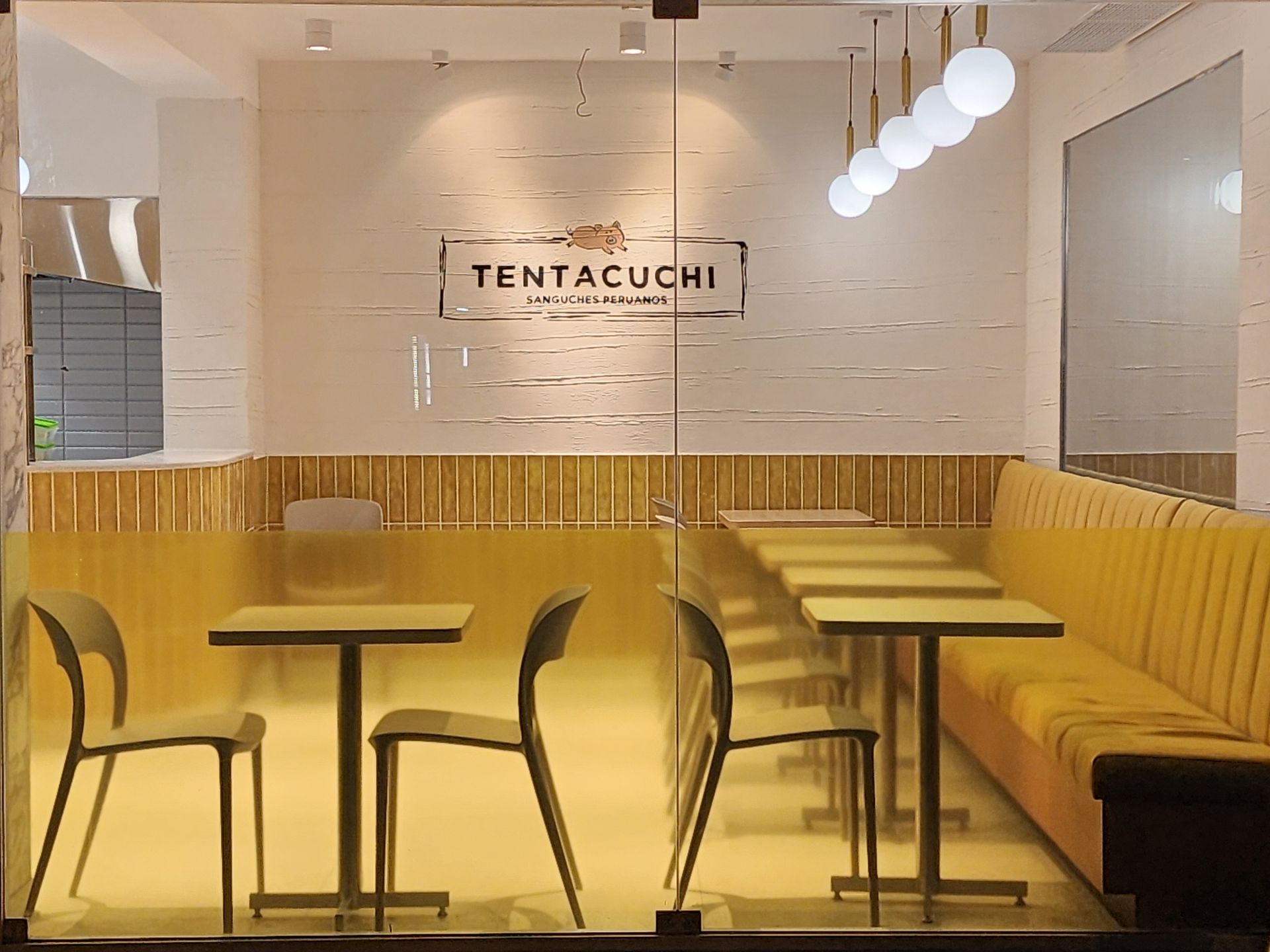 Un restaurante con mesas y sillas y un cartel que dice tentacuchi