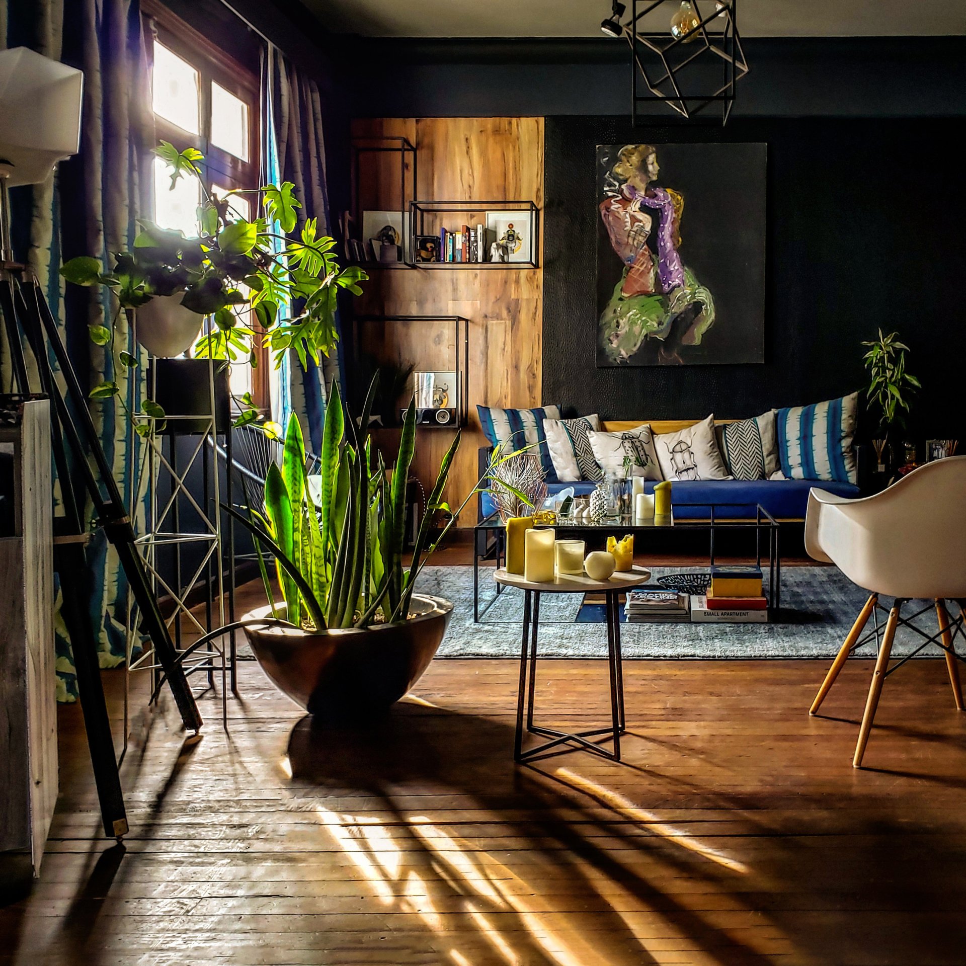 Una sala de estar con un sofá, una silla, una mesa y plantas en macetas.