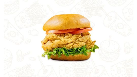 Chicken sandwich with crispy fried chicken, lettuce, tomato, and a golden bun on a white background