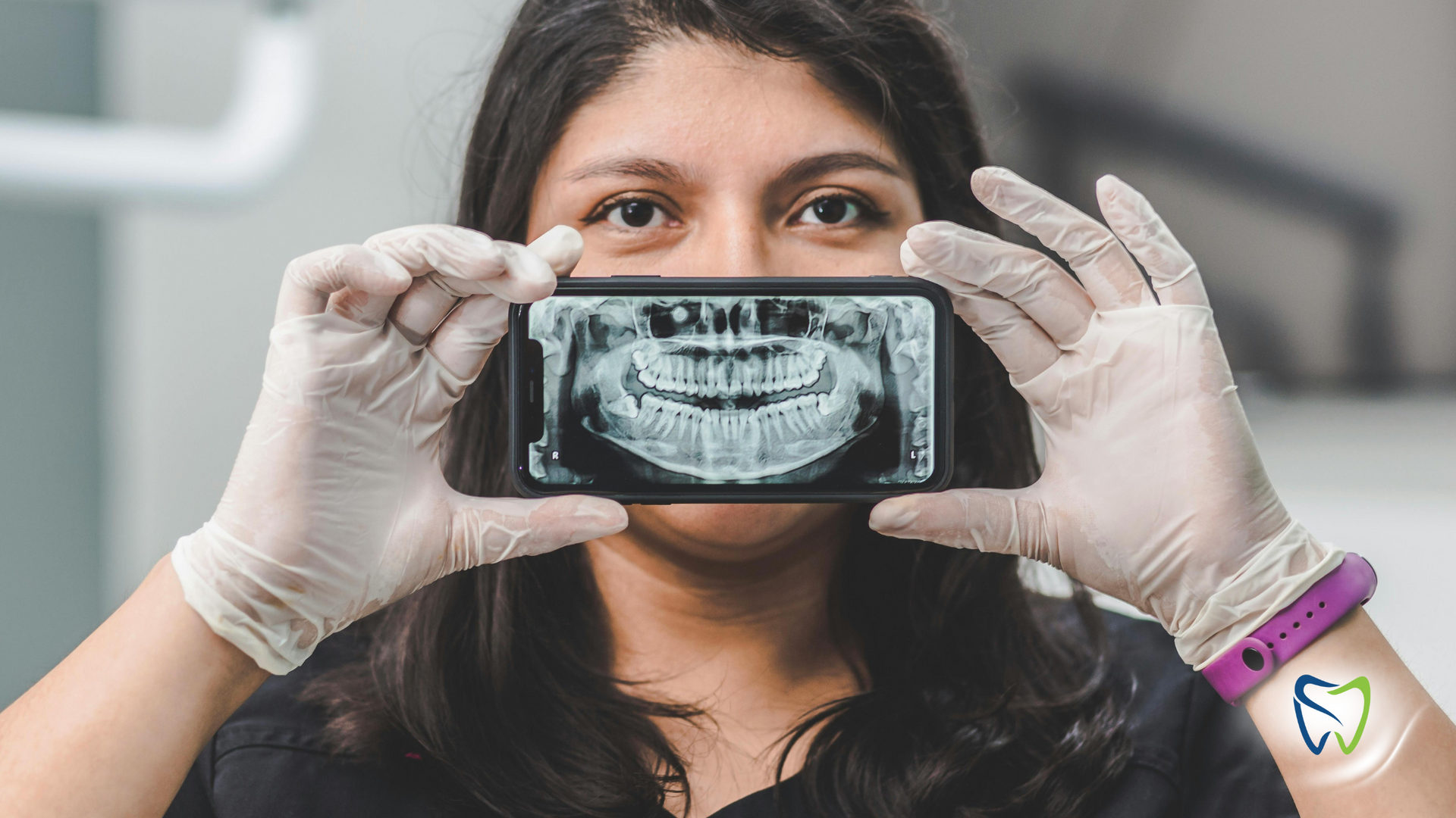 A woman is holding a cell phone in front of her face.