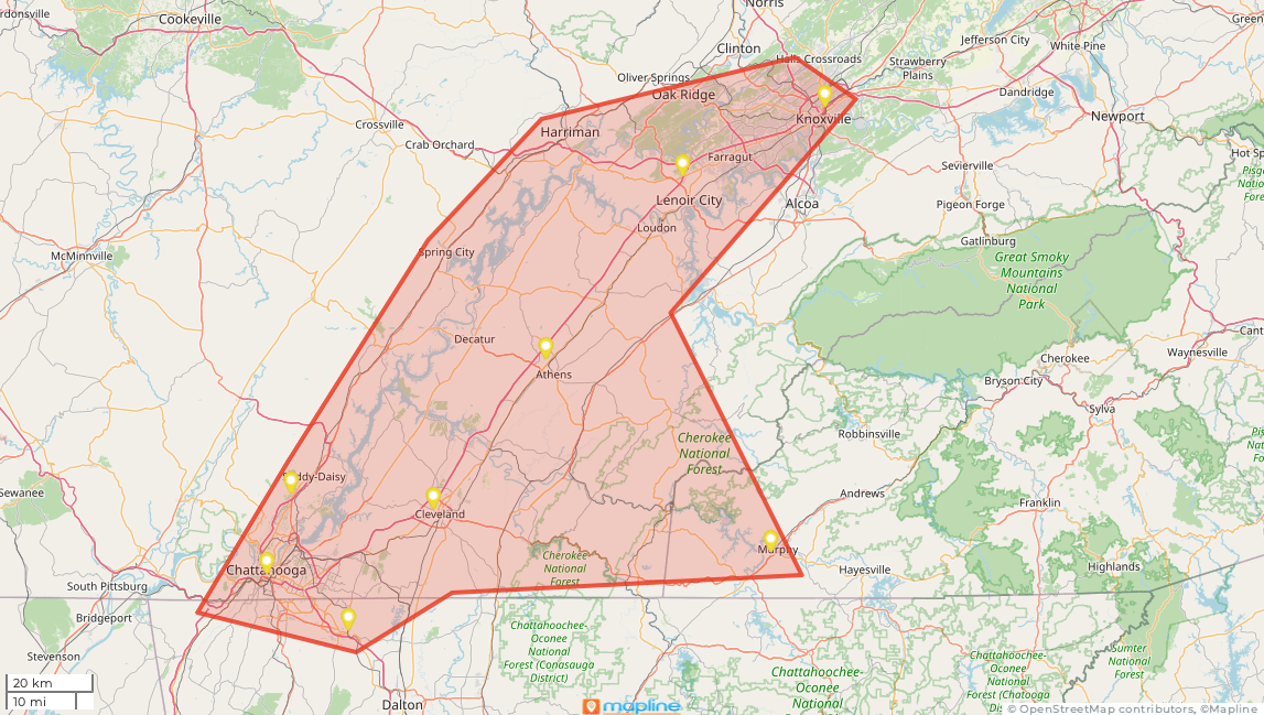 Map of an area outlined in red, with yellow markers indicating locations; mountainous terrain in the background.