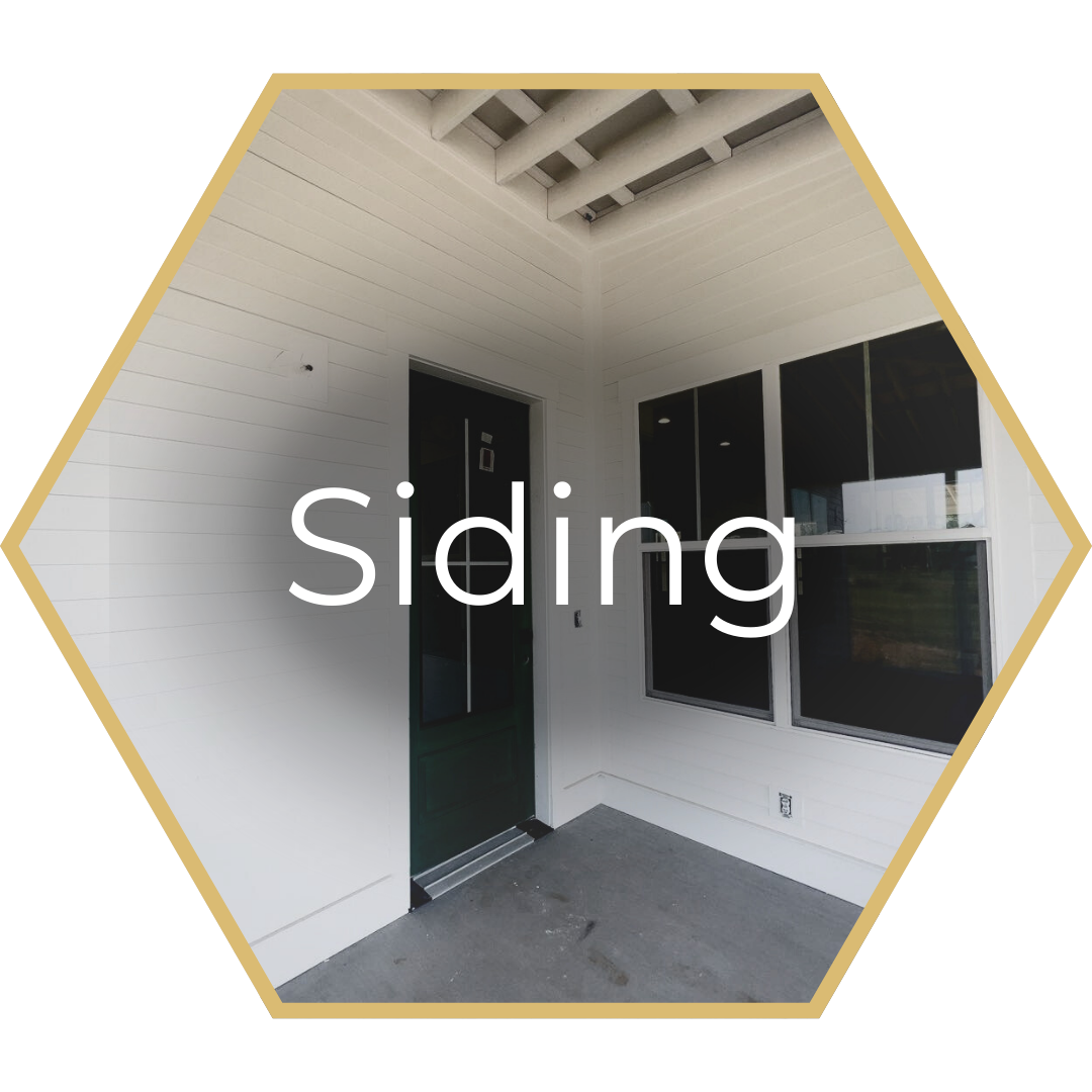 White siding on a building with a dark door and windows.