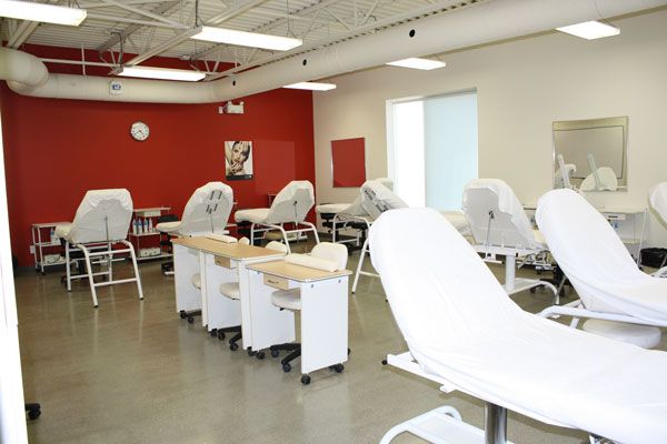 Bright medical treatment room with reclining chairs, white desks, and red accent wall