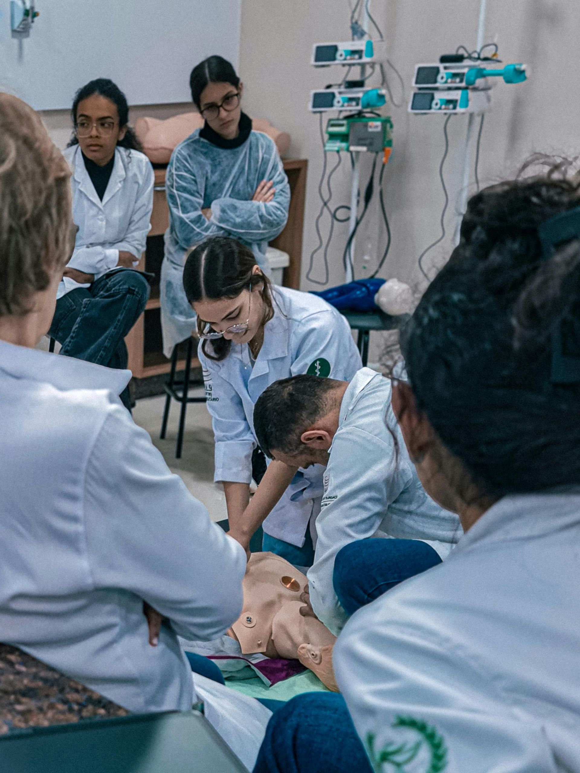 Medical students practicing CPR on a manikin in a clinical training room