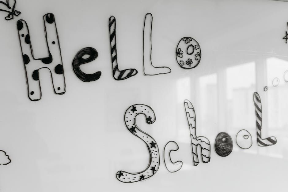 Handwritten “Hello School” on a whiteboard in black patterned letters