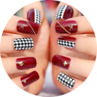 Close-up of burgundy and black-and-white checkered nail art on long manicured nails