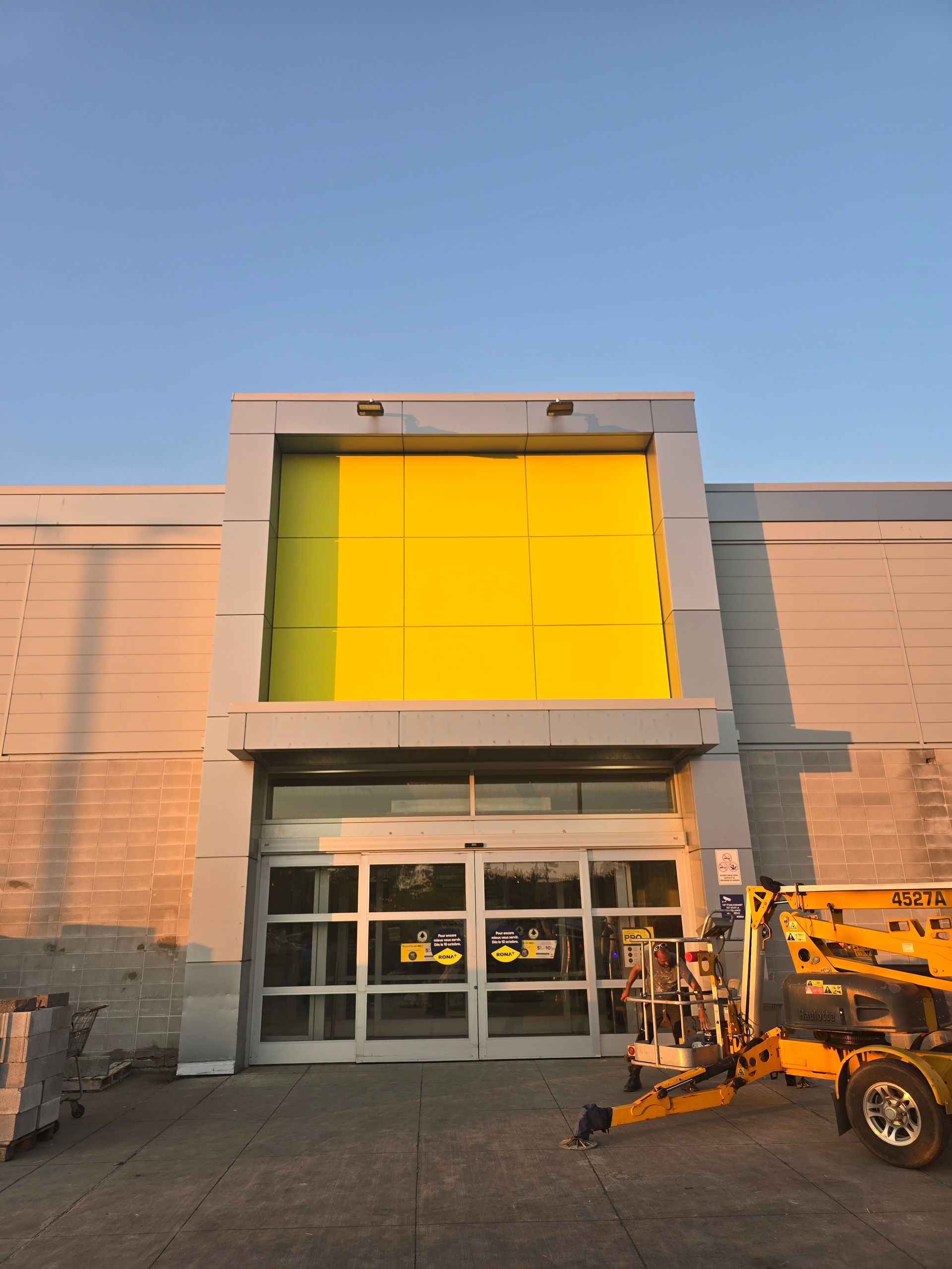 A building with a yellow door and a lift in front of it