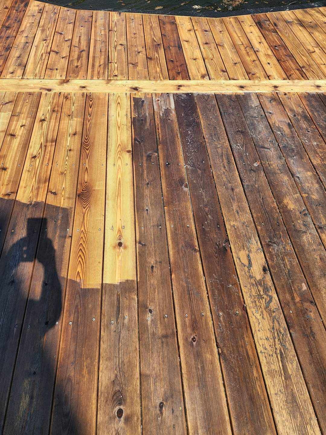 A wooden deck with a shadow of a person on it.