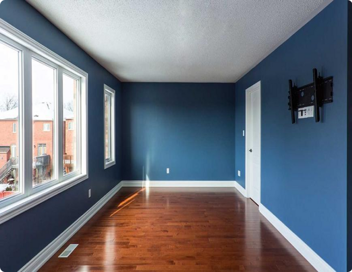 An empty room with blue walls and hardwood floors