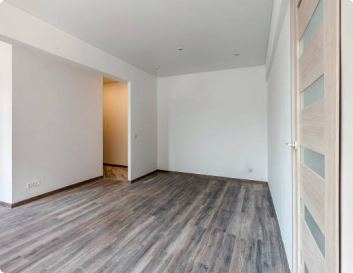 An empty room with hardwood floors and white walls