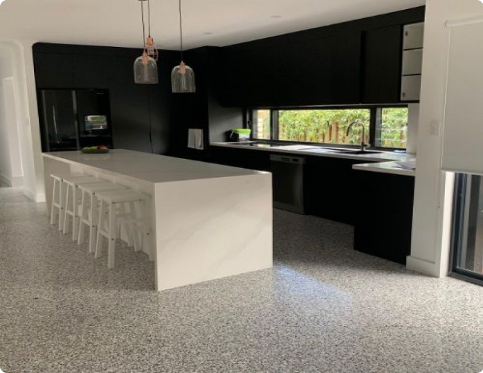 A kitchen with black cabinets and a white island