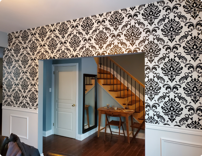 A room with a staircase and a table and chairs