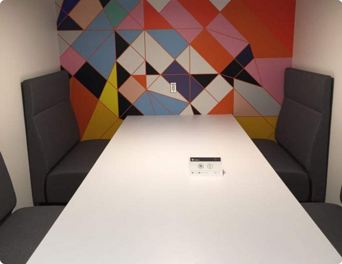 A room with a colorful wall and a white table