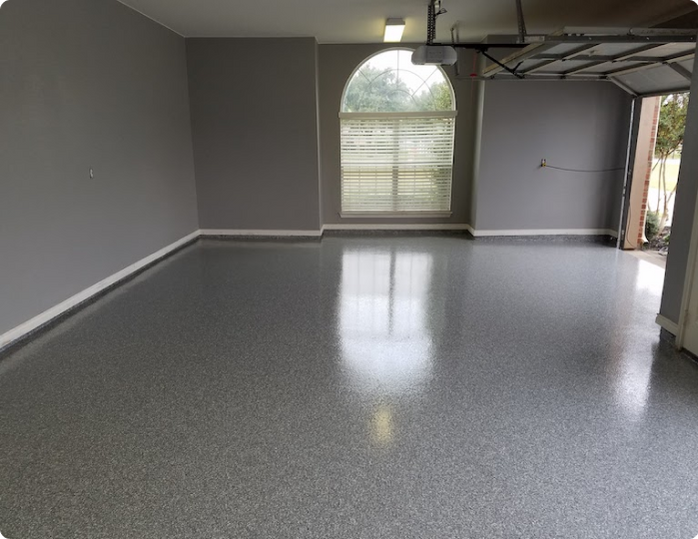 A garage with a gray floor and a window.