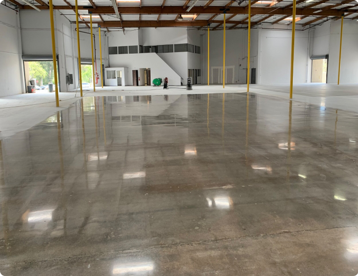 A large empty warehouse with a shiny concrete floor
