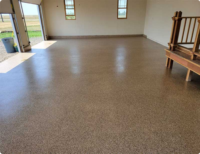 A garage with a concrete floor and a wooden bench.