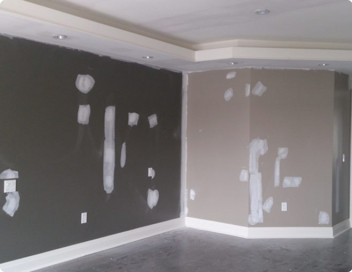 An empty room with a corner that has a few pieces of drywall on it