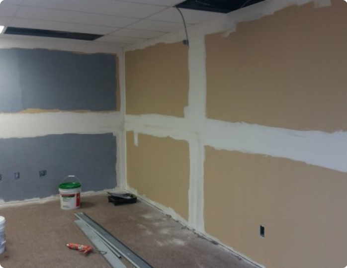 A room with a bucket of paint on the floor