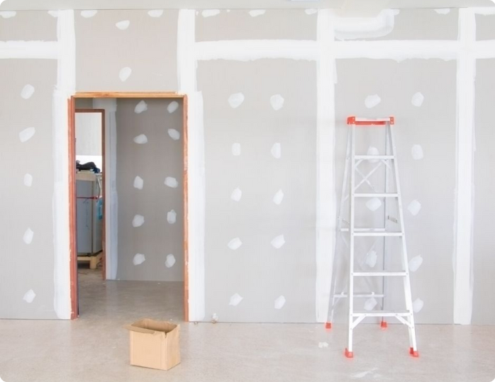 A room with a ladder and a box on the floor.