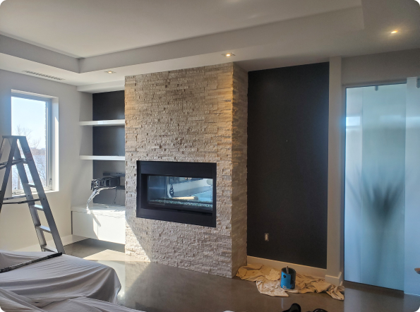 A living room with a fireplace and a ladder in it