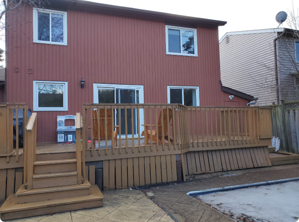 The back of a house with a wooden deck and stairs