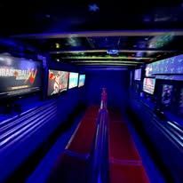 Neon-lit indoor water ride tunnel with blue and purple lights and empty red ride lanes
