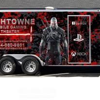 Gaming-themed trailer with red-and-black graphics, a central warrior figure, and PlayStation, Xbox, and Witcher logos
