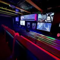 Neon-lit control room with multiple monitors and red accent lighting along a sleek console