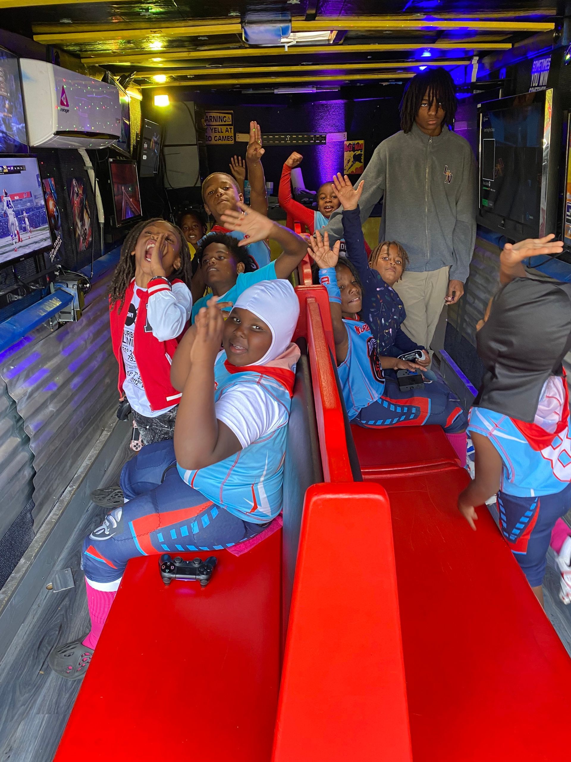 People sitting on a red bus bench inside a decorated party bus, smiling and posing.