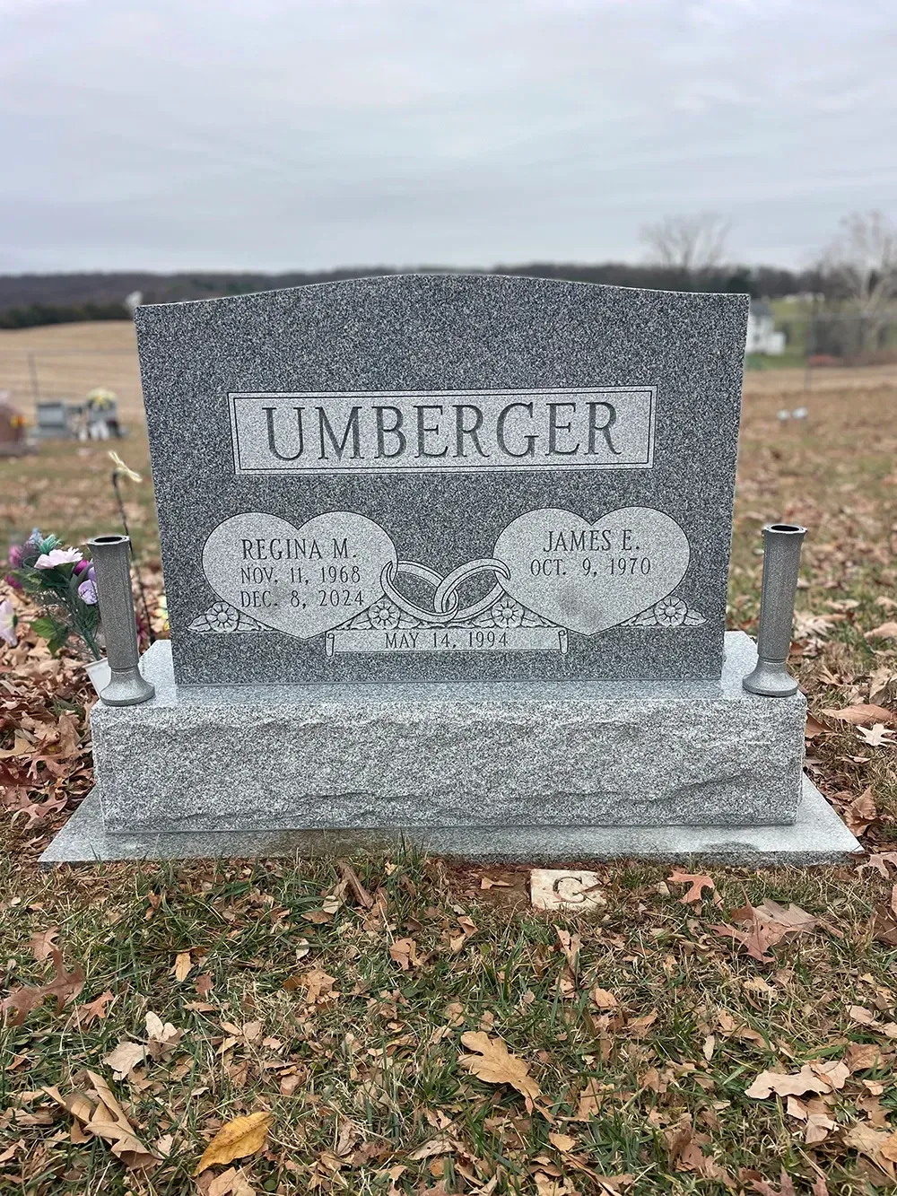 A gray granite headstone inscribed 