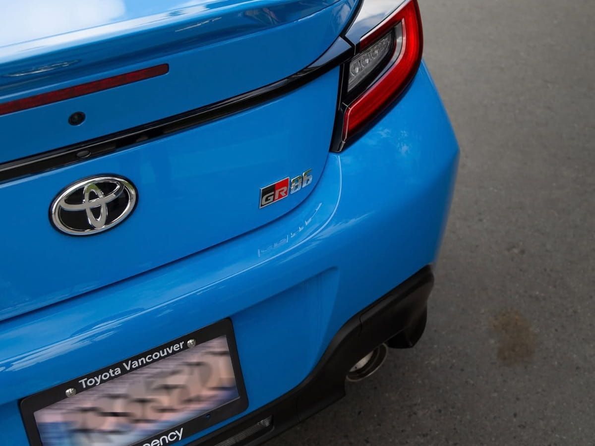 Close-up of the rear of a blue Toyota GR86 showing the taillight and trunk.