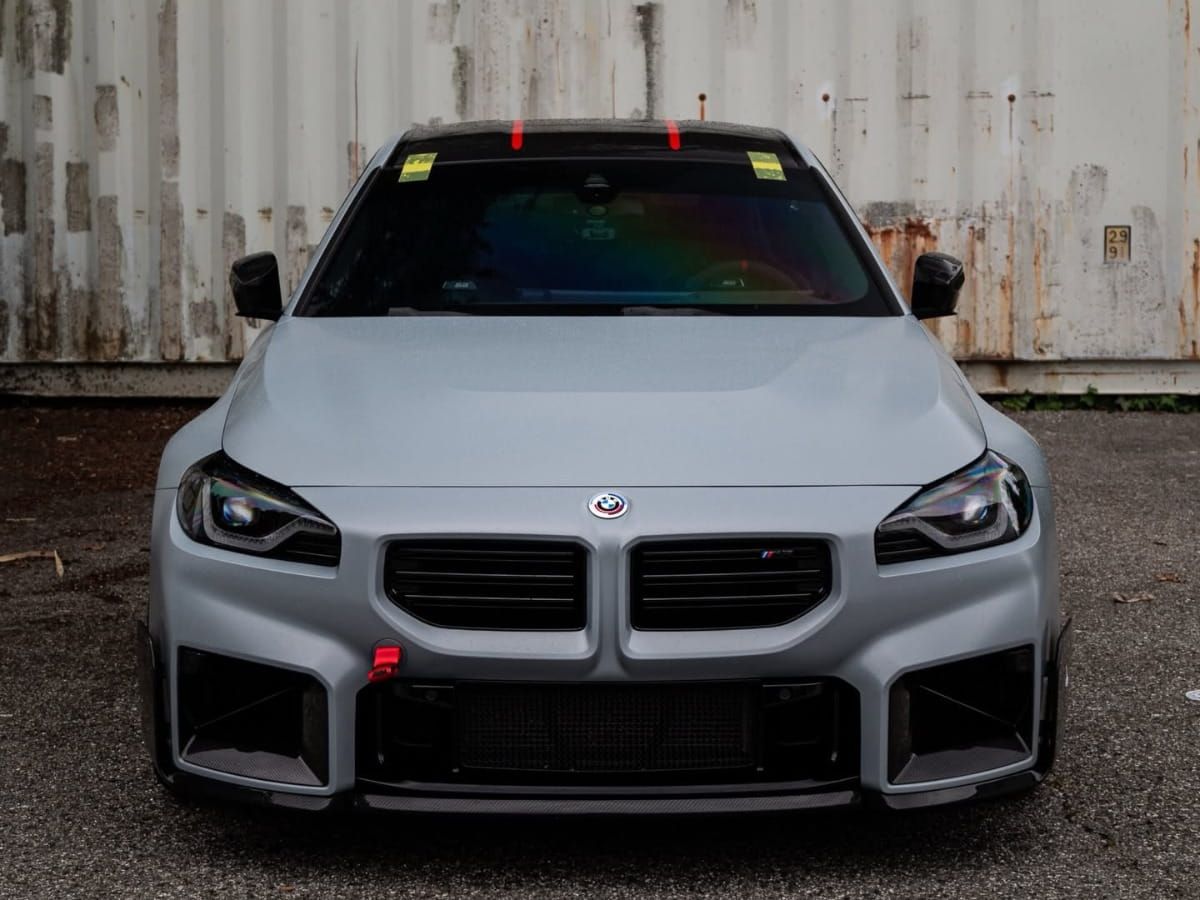 Front view of a gray BMW M2 parked outdoors.