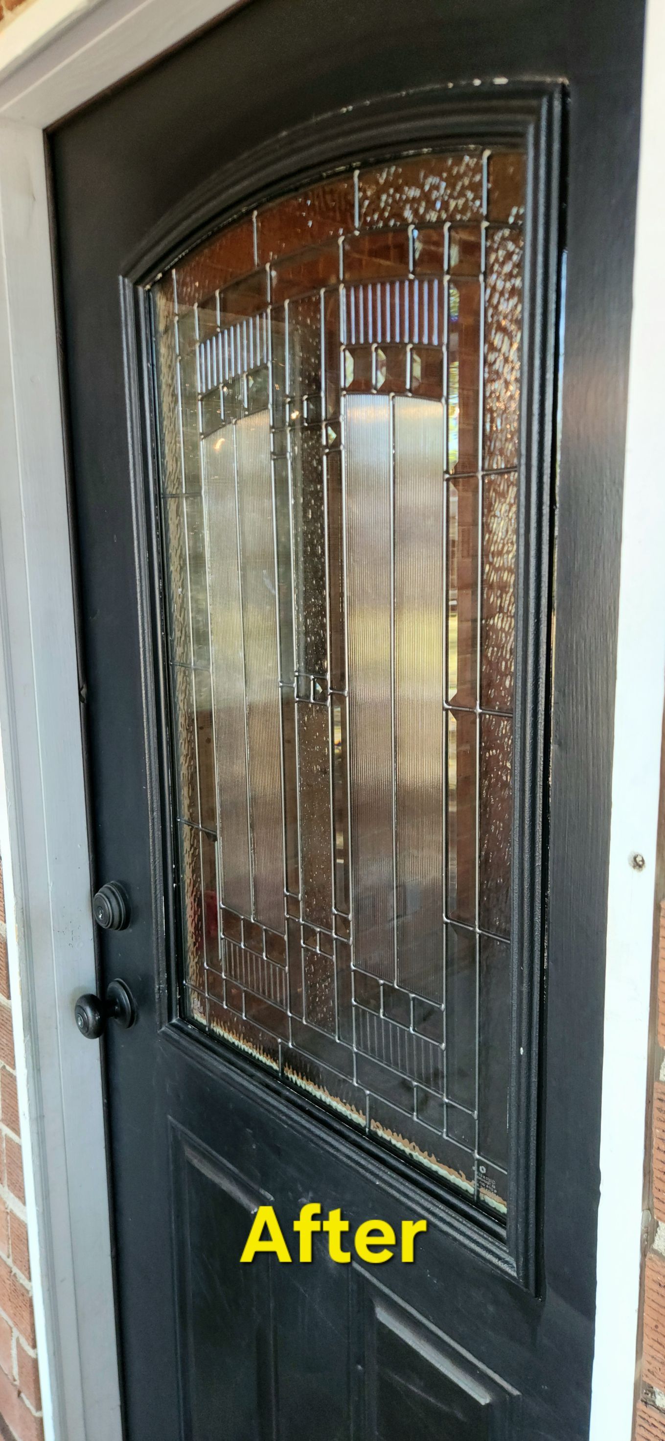Black front door with decorative glass panel and 