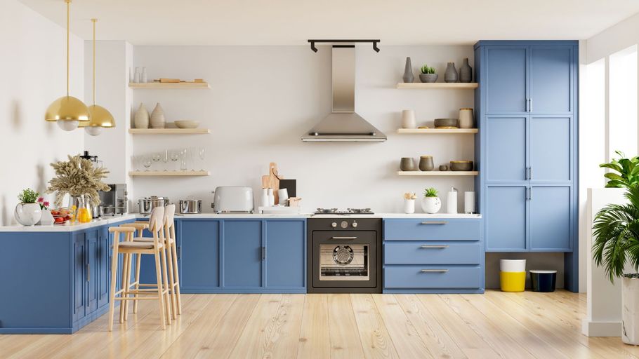 Bright blue-and-white kitchen with open shelves, wooden floor, island, stove, and tall cabinets